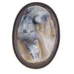 Agate cameo engraved with a long-haired dog lying down.