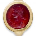 A ROMAN GOLD AND CARNELIAN FINGER RING WITH A BUST OF APOLLO CIRCA 1ST CENTURY B.C.