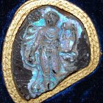 Fragmentary cameo of iridescent glass paste imitating sardonyx, engraved with a draped Apollo advancing to the front,