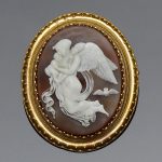 A Victorian oval shell cameo brooch portraying Hypnos in the arms of Nyx