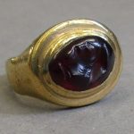 Gold signet ring, the oval bezel set with a garnet intaglio of the head of Mercury